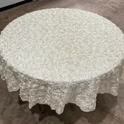 The ivory rosette tablecloth on a round table