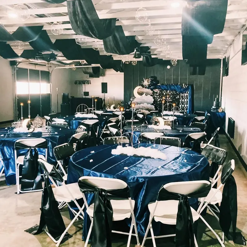 Navy satin tables with black fabric draped across the hall ceiling