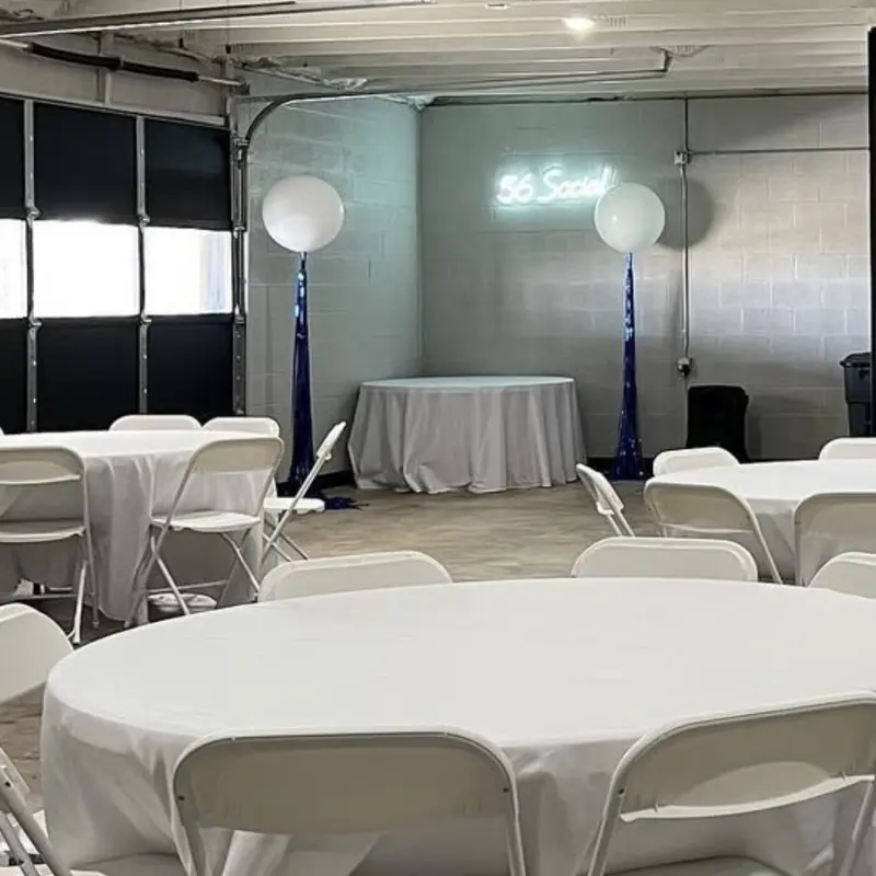 White linens and balloon towers by the 56 Social sign