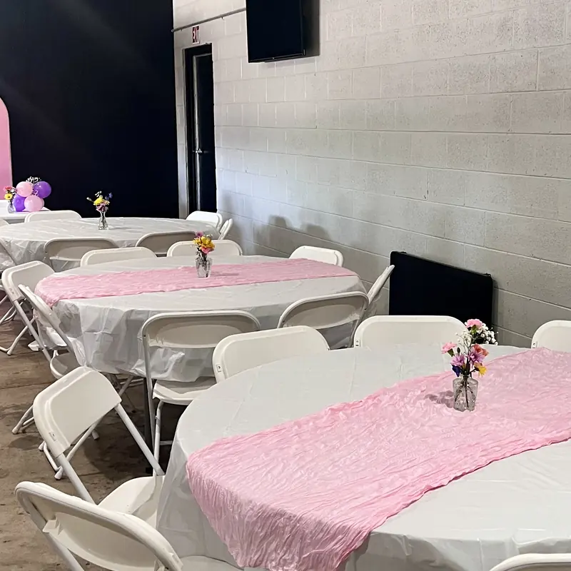 White tables with pink runners and small bouquets