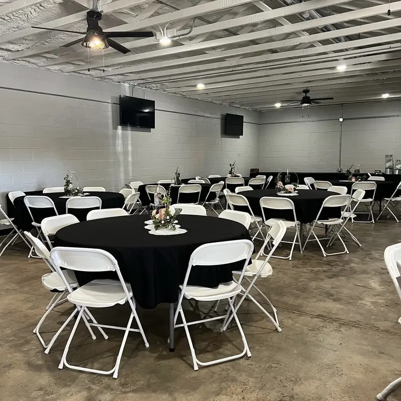 The hall set with black linens and white chairs