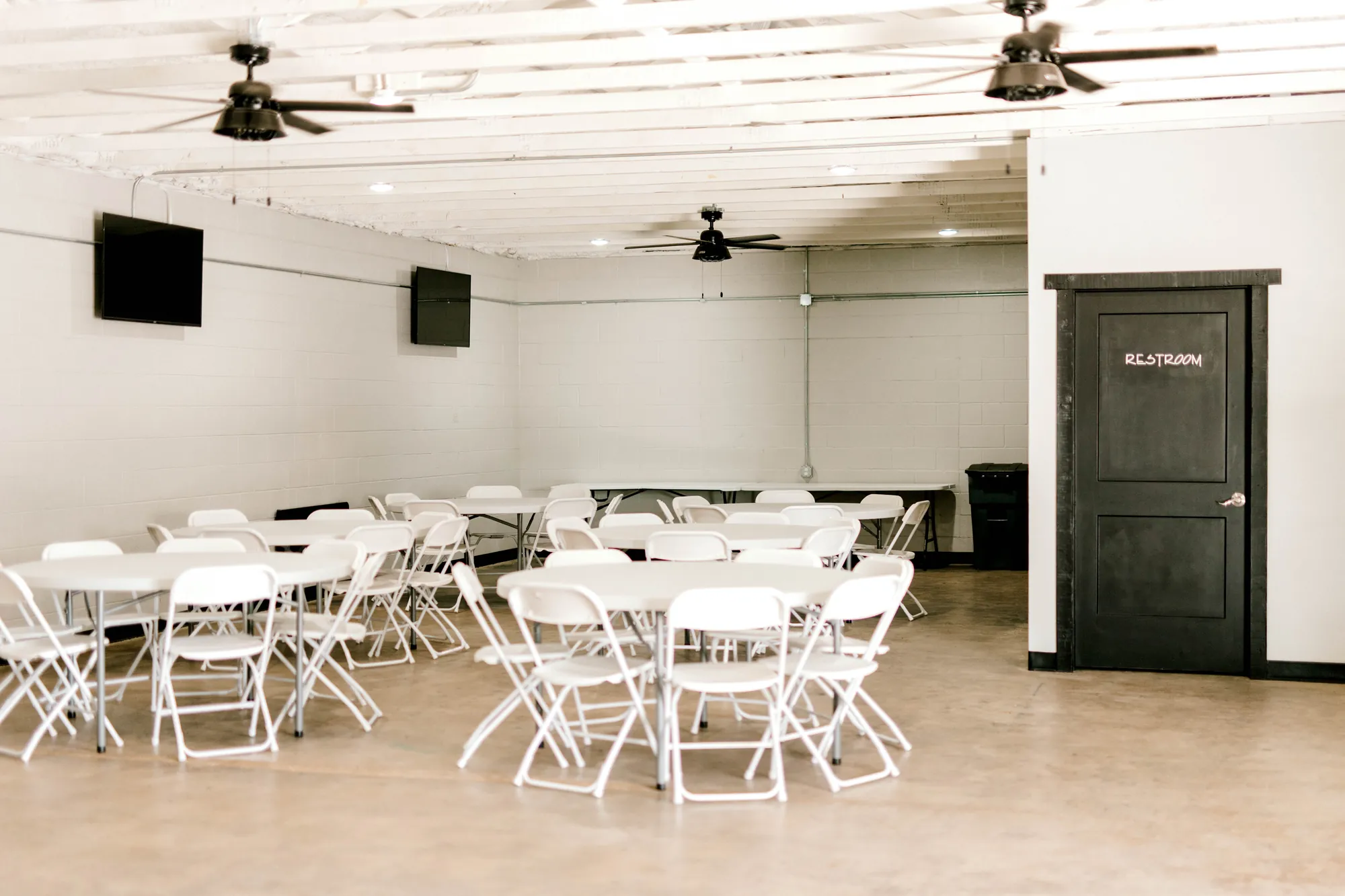 The hall set with white folding chairs and round tables